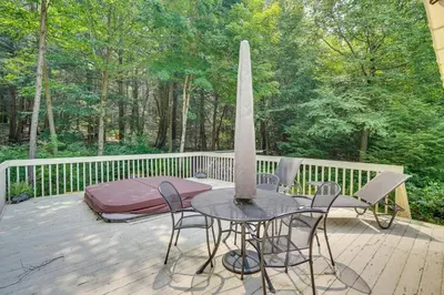 a patio with a table and chairs on a deck at Lakefront Otis Home with Stunning Views and Boats! in Otis