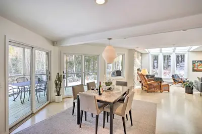 a dining room and living room with a table and chairs at Lakefront Otis Home with Stunning Views and Boats! in Otis