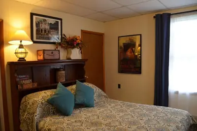 a bedroom with a bed with blue pillows on it at The Bavarian Manor Hotel in Purling