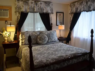 a bedroom with a bed and two windows with curtains at The Bavarian Manor Hotel in Purling
