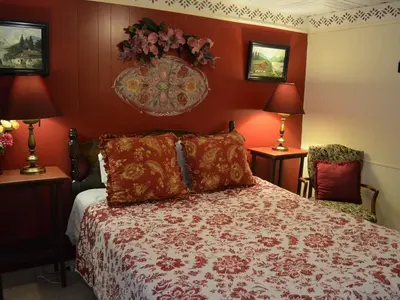 a bedroom with a bed with red walls and two lamps at The Bavarian Manor Hotel in Purling