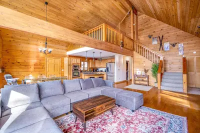 a living room with a couch and a table at Beautiful Chalet, mins to Hunter/Windham slopes in Jewett
