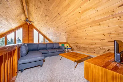 a living room with a couch and a tv in a cabin at Beautiful Chalet, mins to Hunter/Windham slopes in Jewett