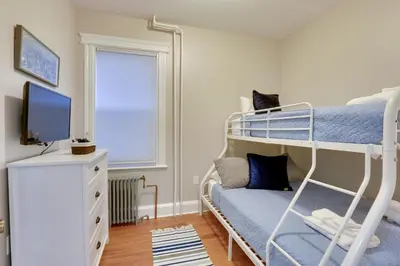 a bedroom with two bunk beds and a television at Jersey City Apartment Near Liberty State Park in Jersey City