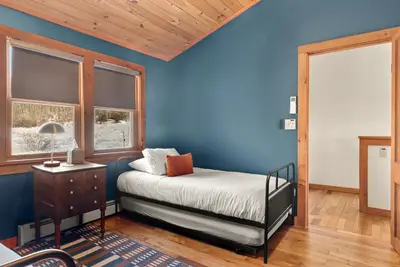 a bedroom with blue walls and a bed and windows at Stella Firma in Bloomville