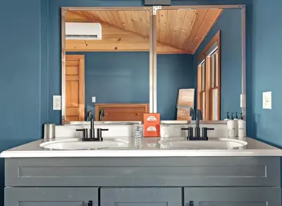 a bathroom with two sinks and a large mirror at Stella Firma in Bloomville