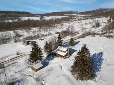 an aerial view of a snow covered field with trees at Stella Firma in Bloomville
