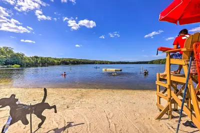 a person sitting in a lifeguard chair on a beach at Pet-Friendly Home with Deck at Big Bass Lake! in Gouldsboro