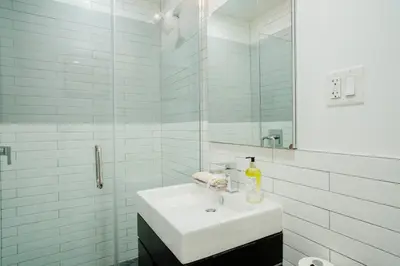 a white bathroom with a sink and a mirror at 1288-4R Newly furnished Prime UES 2BR in New York