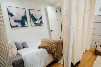 a mirror in a room with a couch and two pictures at 1288-4R Newly furnished Prime UES 2BR in New York