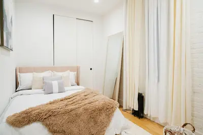 a bedroom with a large bed with a brown blanket at 1288-4R Newly furnished Prime UES 2BR in New York