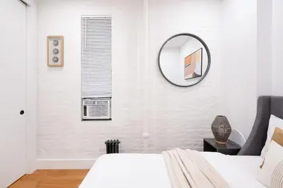 a bedroom with a bed and a mirror on the wall at 1288-3RS New Renovated 2 Bedrooms in New York