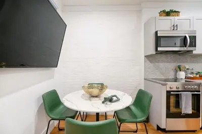 a small kitchen with a table and green chairs at 1288-3RS New Renovated 2 Bedrooms in New York