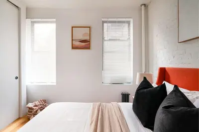 a bedroom with a bed with white walls and windows at 1288-3RS New Renovated 2 Bedrooms in New York