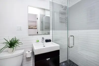 a white bathroom with a sink and a shower at 1288-3RS New Renovated 2 Bedrooms in New York