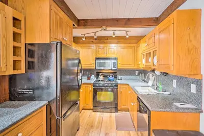 a kitchen with wooden cabinets and a stainless steel refrigerator at Berkshires Getaway Less Than 1 Mi Skiing and Hiking! in Shelburne Falls