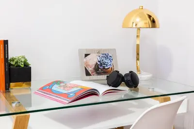 a glass desk with a book and a lamp at 1435-2 3 Bedrooms 2Bath W D UES in New York
