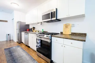 a kitchen with white cabinets and a stove top oven at 1435-2 3 Bedrooms 2Bath W D UES in New York