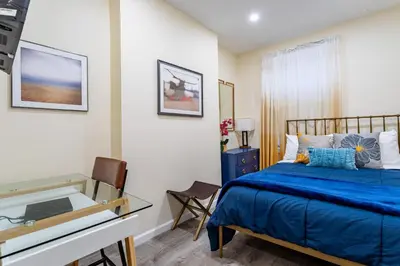 a bedroom with a blue bed and a desk at Upscale Relax 2 Bedroom near Yankee Stadium 14 min drive in New Rochelle