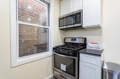 a kitchen with a stove top oven next to a window at Upscale Relax 2 Bedroom near Yankee Stadium 14 min drive in New Rochelle