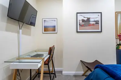 a room with a desk and a tv and a table at Upscale Relax 2 Bedroom near Yankee Stadium 14 min drive in New Rochelle
