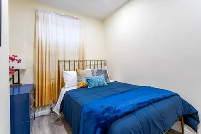 a bedroom with a blue bed and a window at Upscale Relax 2 Bedroom near Yankee Stadium 14 min drive in New Rochelle