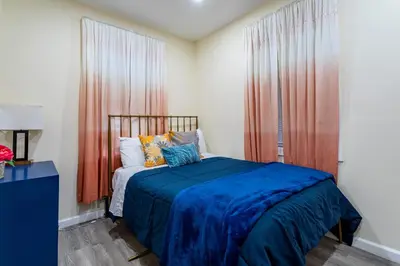 a bedroom with a bed with blue sheets and a window at Upscale Relax 2 Bedroom near Yankee Stadium 14 min drive in New Rochelle