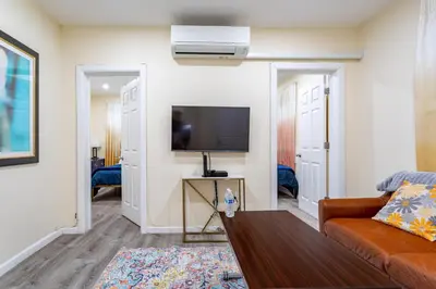 a living room with a couch and a flat screen tv at Upscale Relax 2 Bedroom near Yankee Stadium 14 min drive in New Rochelle