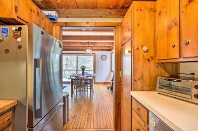 a kitchen with a refrigerator and a dining room at West Cornwall Cabin about 4 Mi to Covered Bridge! in West Cornwall