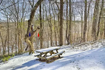 a picnic table in the snow in the woods at West Cornwall Cabin about 4 Mi to Covered Bridge! in West Cornwall