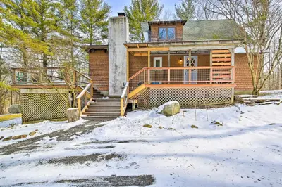 a home with a snow covered yard in front of it at West Cornwall Cabin about 4 Mi to Covered Bridge! in West Cornwall