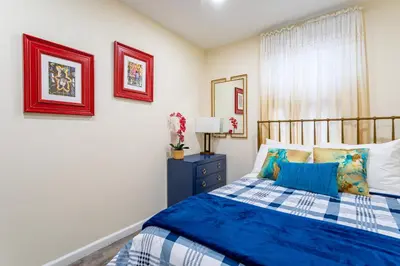 a bedroom with a blue and white bed and a window at Luxe Retreat 2 Bedroom Hideaway Minutes from NYC in New Rochelle