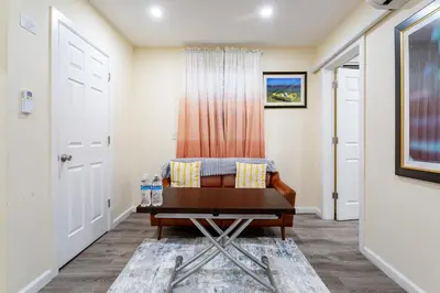 a living room with a chair and a table at Luxe Retreat 2 Bedroom Hideaway Minutes from NYC in New Rochelle