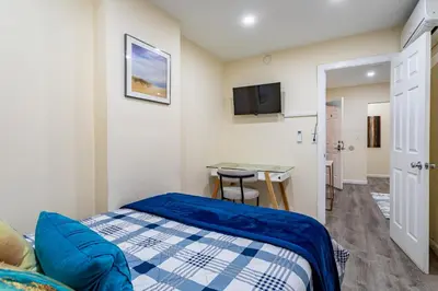 a small bedroom with a bed and a desk at Luxe Retreat 2 Bedroom Hideaway Minutes from NYC in New Rochelle