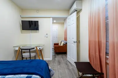 a room with a bed and a table and a desk at Luxe Retreat 2 Bedroom Hideaway Minutes from NYC in New Rochelle