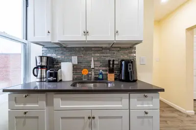 a kitchen with white cabinets and a sink at Luxe Retreat 2 Bedroom Hideaway Minutes from NYC in New Rochelle