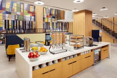 a cafeteria with a counter with fruit on it at Home2 Suites By Hilton New York Times Square in New York