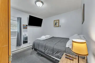 a bedroom with a bed and a flat screen tv at Babe Ruth Apt 2 All Star Baseball Rentals in Oneonta