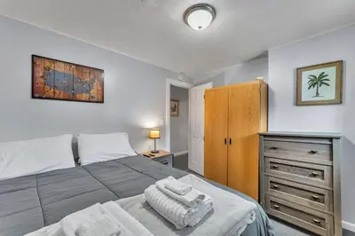 a bedroom with a large bed with a wooden cabinet at Babe Ruth Apt 2 All Star Baseball Rentals in Oneonta