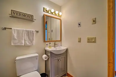 a bathroom with a toilet and a sink and a mirror at Idyllic Mount Snow Condo with View and Amenities! in West Dover