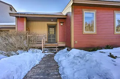 a red house with snow in front of it at Idyllic Mount Snow Condo with View and Amenities! in West Dover
