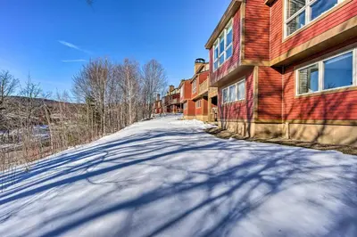 a snow covered road in front of a building at Idyllic Mount Snow Condo with View and Amenities! in West Dover