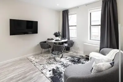 a living room with a table and chairs at Modern Spacious Apartment in Chelsea in New York
