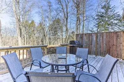 a patio with a table and chairs on a deck at Game Room, Fire Pit Family-Friendly Poconos Haven in East Stroudsburg