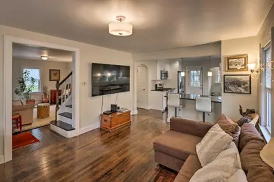 a living room with a couch and a tv and a kitchen at Bridgeport Vacation Rental - Walk to Beach! in Bridgeport