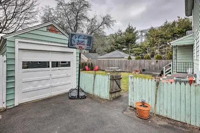 a garage with a basketball hoop next to a fence at Bridgeport Vacation Rental - Walk to Beach! in Bridgeport