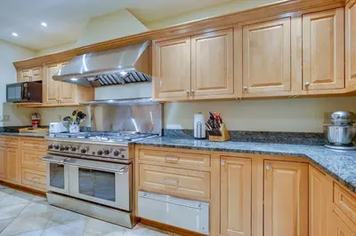 a kitchen with wooden cabinets and stainless steel appliances at Luxury Vacation Rental in the Berkshires! in Williamstown