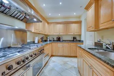 a kitchen with wooden cabinets and a stove top oven at Luxury Vacation Rental in the Berkshires! in Williamstown