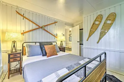 a bedroom with a bed and two surfboards on the wall at Stylish and Cozy Cabin, Walking Distance to Big Bass Lake in Gouldsboro