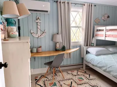 a bedroom with a desk and a bed and a table at Stylish and Cozy Cabin, Walking Distance to Big Bass Lake in Gouldsboro